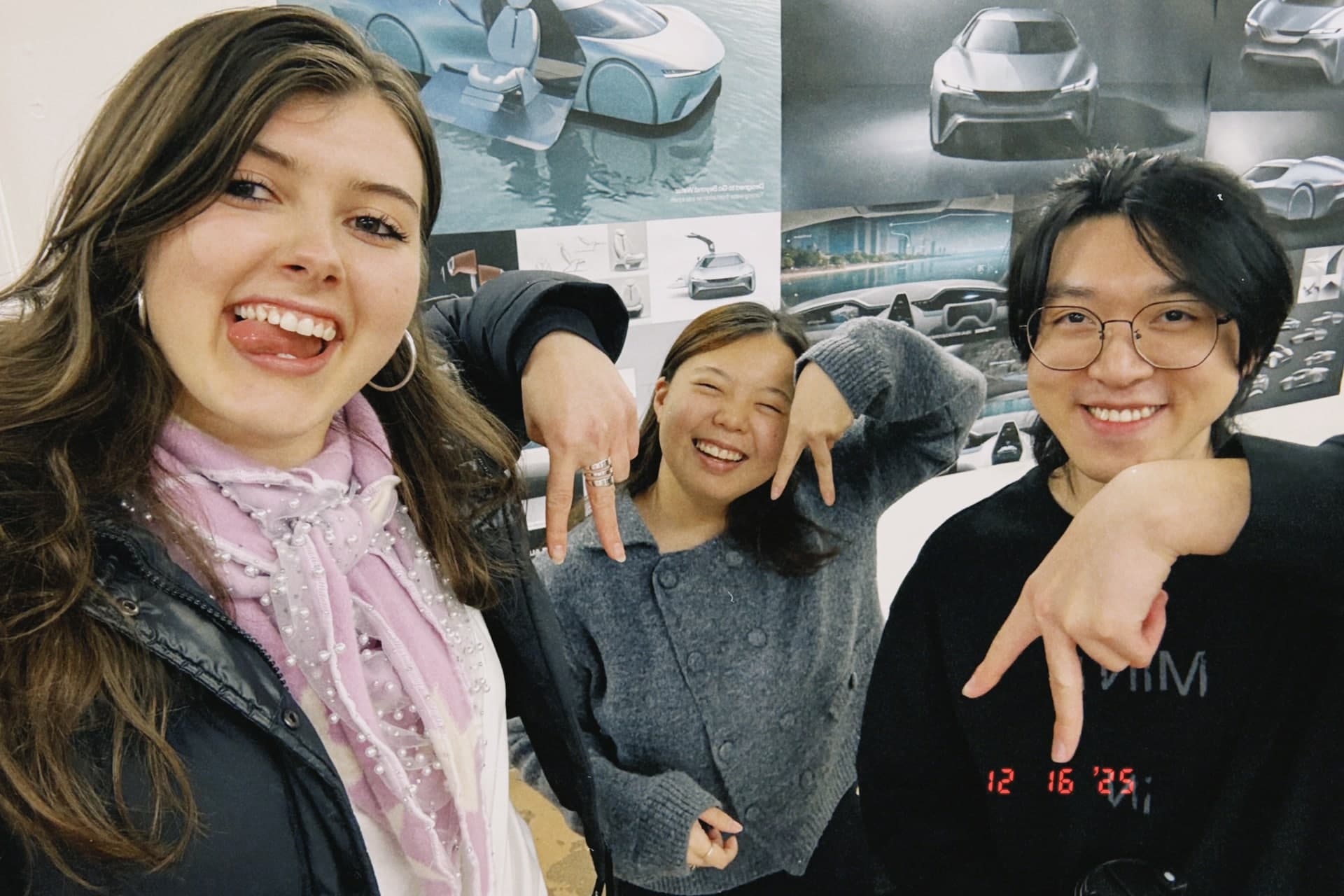 Three AEON teammates taking a selfie in front of their vehicle design boards